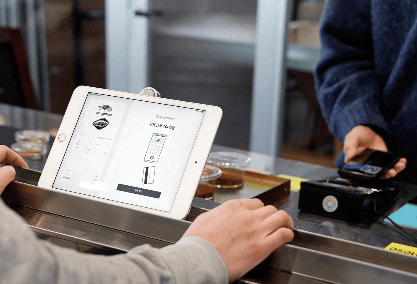 카페에서 셀프오더 태블릿으로 고객이 직접 결제하는 모습